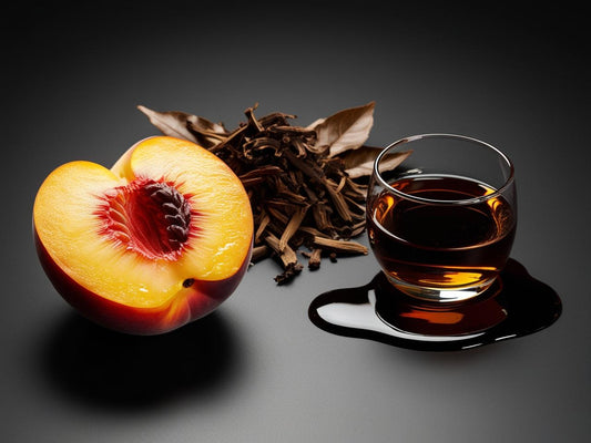 Half-peeled peach, dried leaves, and a glass of dark liquid on a dark background