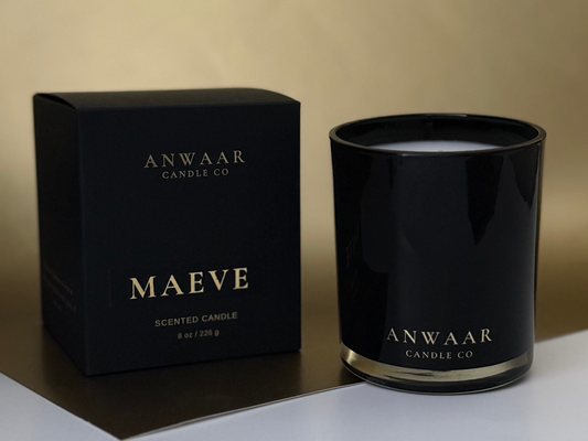 Black candle and packaging with 'Anwaar Candle Co' branding on a neutral background